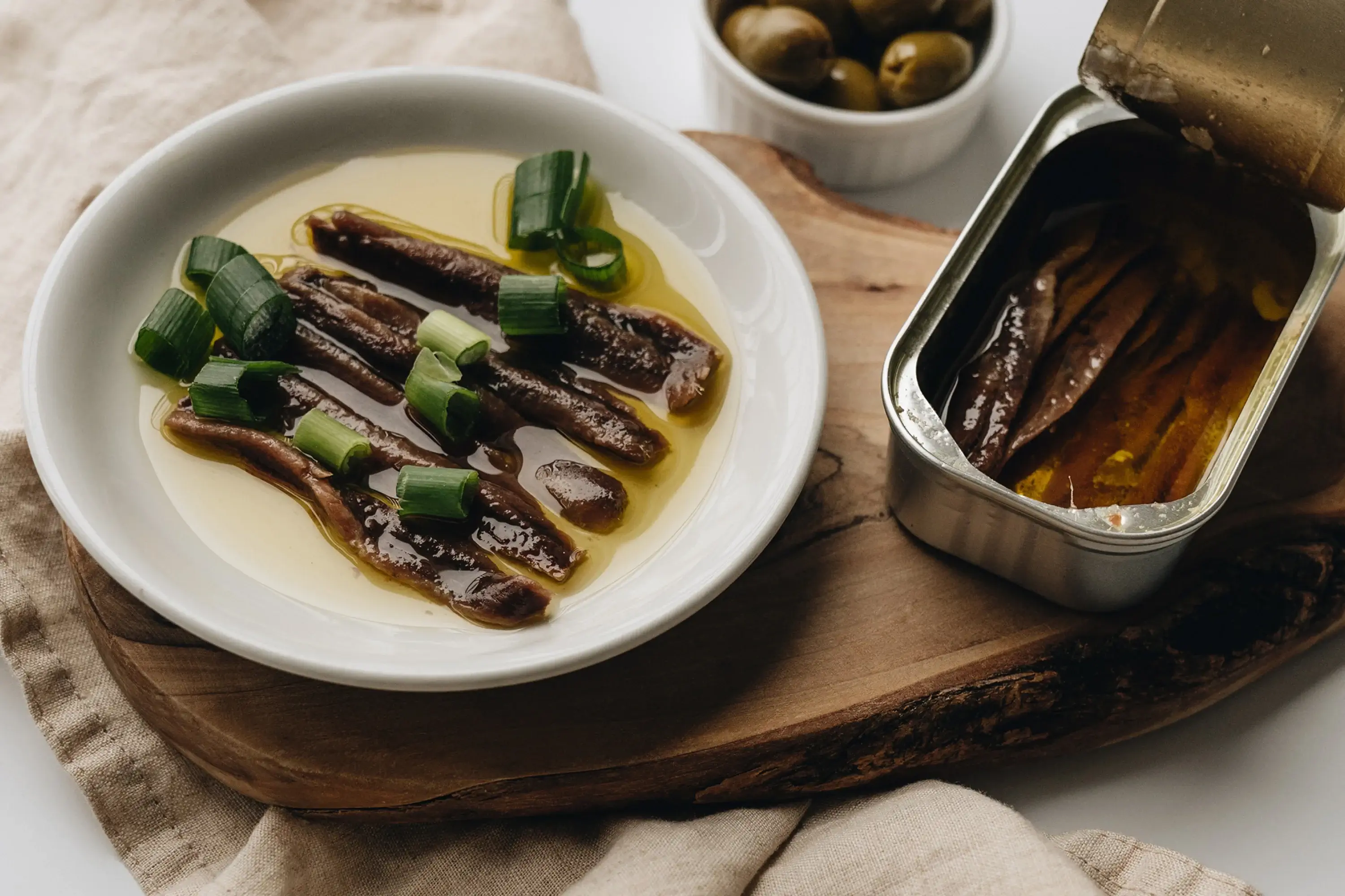 canned fish, olive oil, and green onions in a small bowl